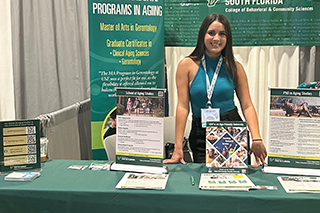 Sayla Victores stands at an information table at a recent conference.
