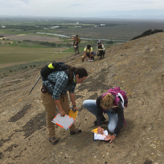 Geology students measure and observe geologic features in the field.