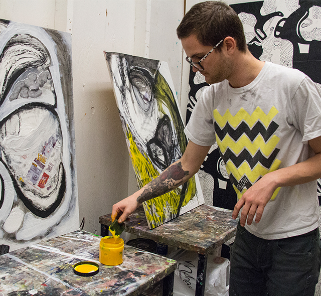 Student expressing creativity while painting in the studio.