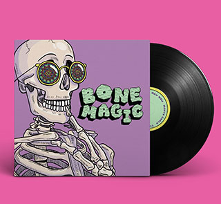 Vinyl record cover designed by 2020 graduate Emily Butler: A smiling skull wears a pair of yellow sunglasses with lenses that feature a brightly colored mandala print. Mint-colored text to the skull's right reads "BONE MAGIC."