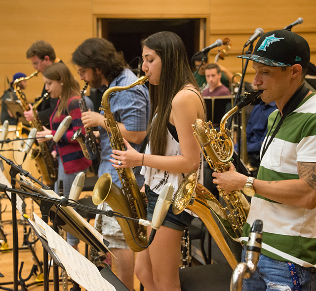 Jazz students rehearsing their saxophone parts for a performance.