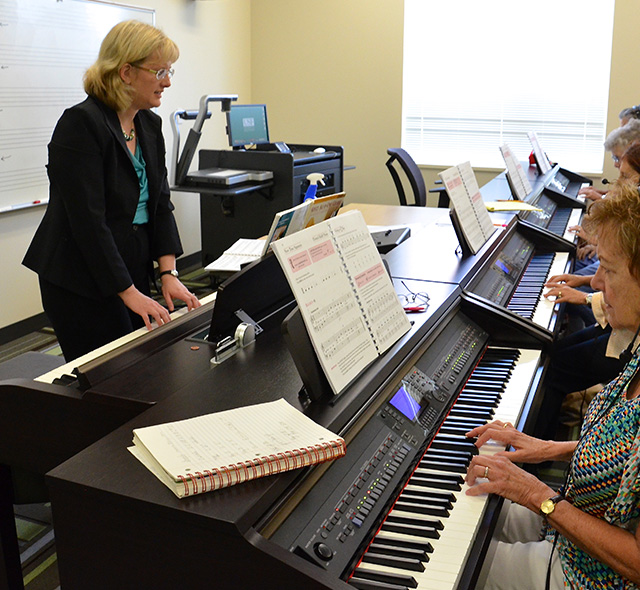 Music Education teacher during a research session with a class of senior citizens attending a piano class.