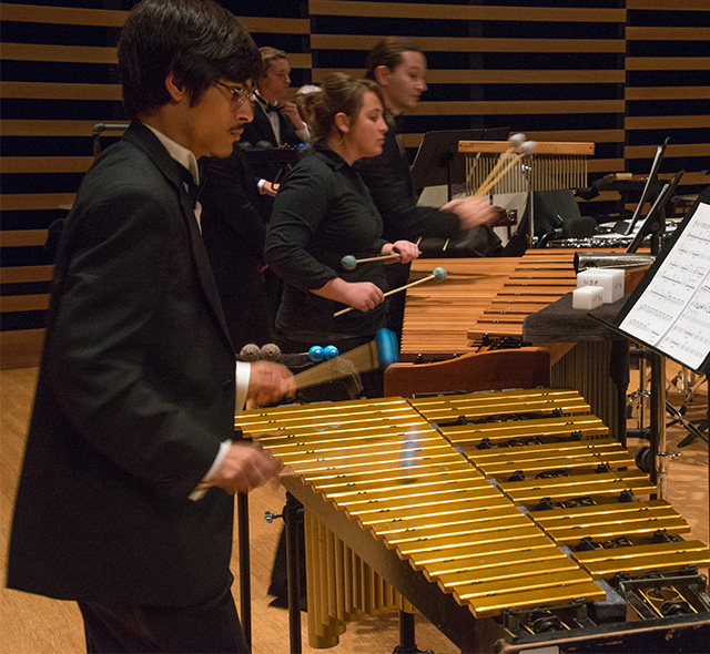 Students playing marimbas on stage.