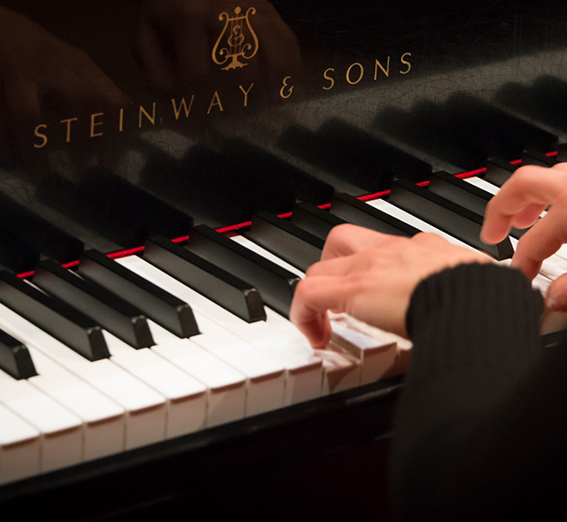 Piano student practicing a melody on a Steinway and Sons piano.