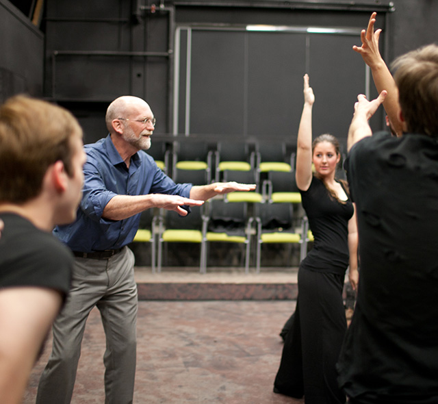 Theatre students and professor rehearsing movement and expressions.