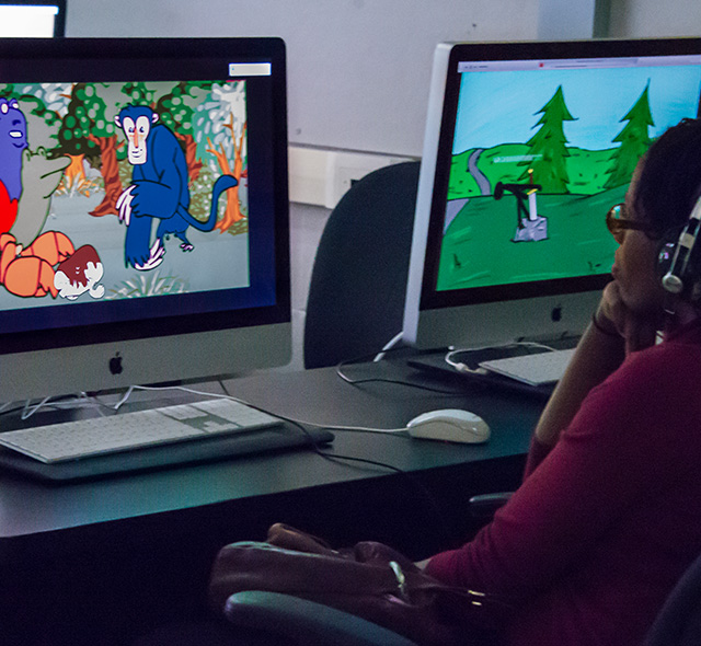 Art student in the 2D animation studio reviewing a project on screen.