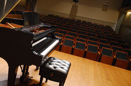Stage view of grand piano overlooking audience seating.