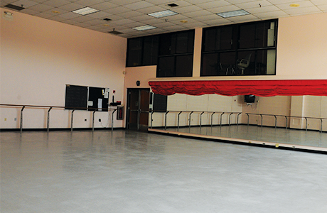 Overview of dance studio floor, mirrors and bars.
