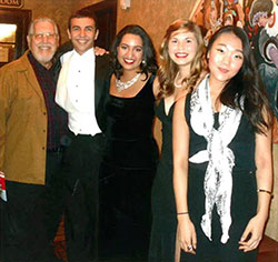 Professor Warren Jaworski poses with current studio singers in concert attire