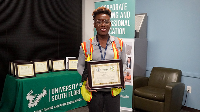 amazon worker stands with certificate after graduation from lean six sigma program