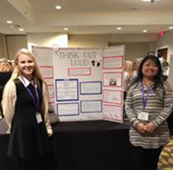 Students in front of presentation at conference