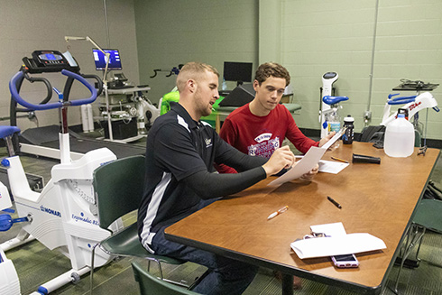 Student and instructor reviewing test results in exercise science lab