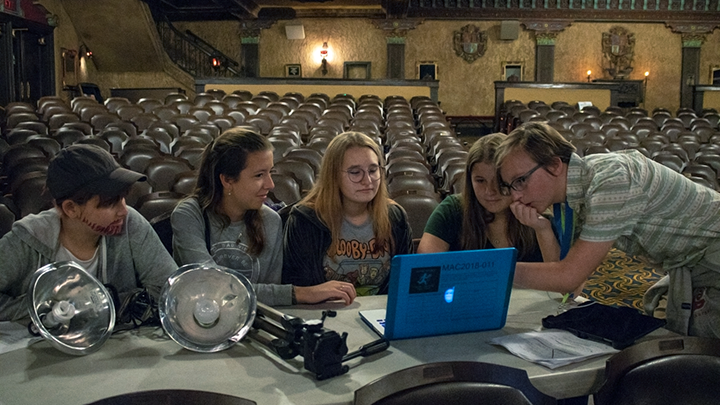 Camp counselor helps students edit their film project