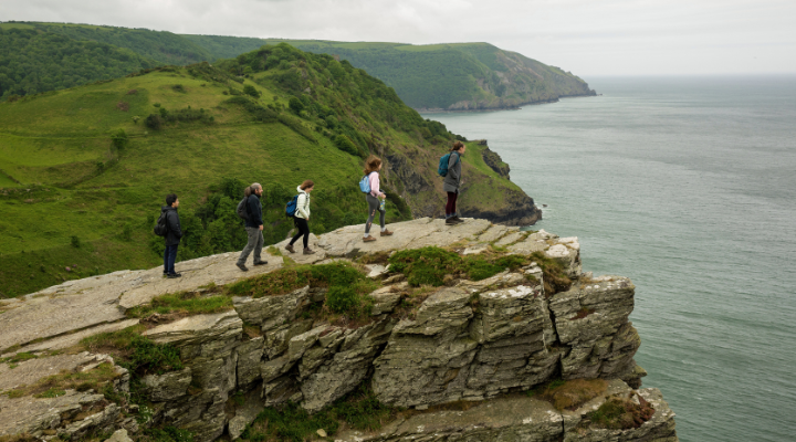 Five Honors Semester in Exeter students and faculty explore a cliff overlooking the seaside.