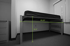 Dorm bed in Holly apartment. Shows dimensions of bed frame, 33.5 inches tall by 85.25 inches wide.