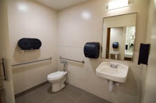 Toilet and sink in enclosed bathroom with two towel racks