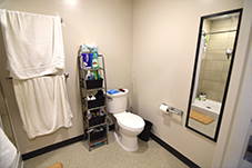 Toilet with towel rack and bathroom shelf to the left