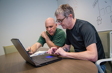 Faculty member getting help from someone on computer