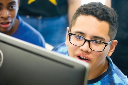 Male student with a surprised look on his face at a computer.