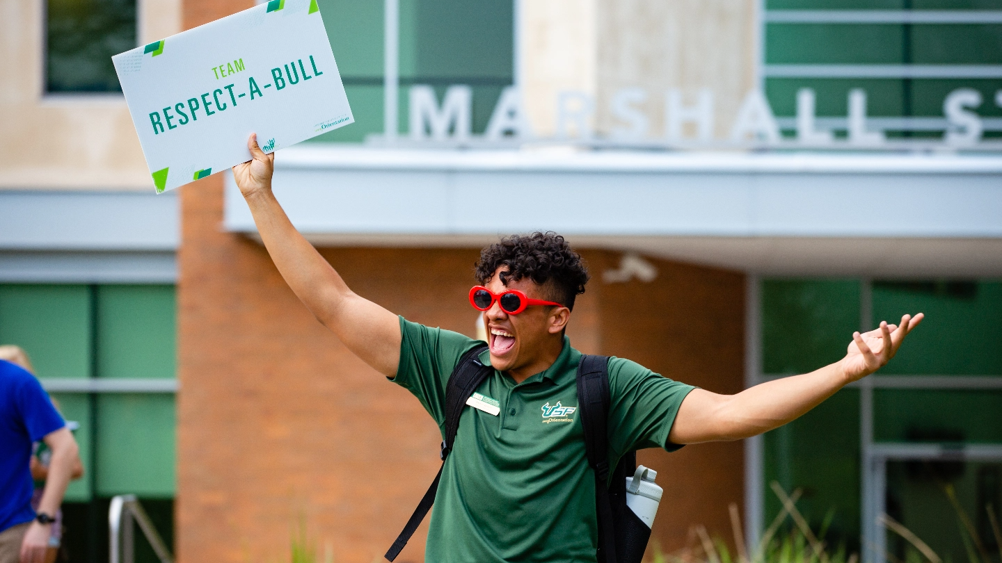 USF Orientation leader holding up a sign that says "Team Respect-A-Bull".