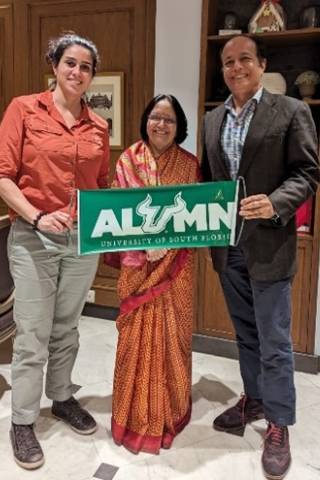Vanessa Martinez, Aruna Dasgupta, and alumnus entrepreneur Ranvir Singh proudly display a USF alumni banner