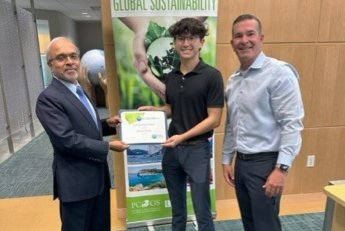 USF PCGS student Gaven Simon, center, is pictured with Dr. Govindan Parayil (left), Dean of the Patel College of Global Sustainability at the University of South Florida, and Florida Green Building Coalition Executive Director C.J. Davila.