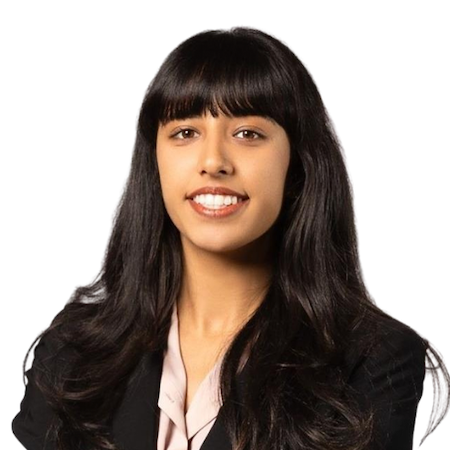 A woman with long brown hair smiles wearing a black suit jacket and pink blouseuit h