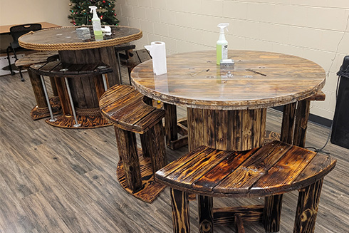 Two custom wood tables and chairs spread throughout the breakroom.