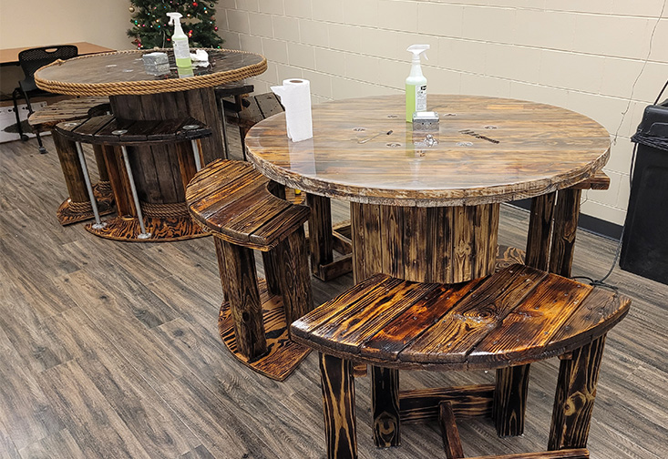 Two custom wood tables and chairs spread throughout the breakroom.