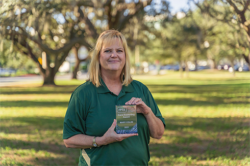 Mary Colini holding her Carol Easterinling Award.