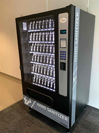 Hand sanitizer vending machine located in a hallway.