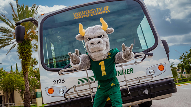 Rocky D. Bull in front of a Bull Runner Bus.