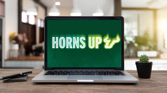 a laptop with a green wallpaper that reads "Horns Up" with the USF logo