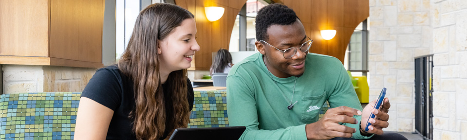 Two students checking what to do next after they've been accepted.