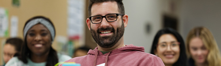 A smiling transfer student sitting in class.