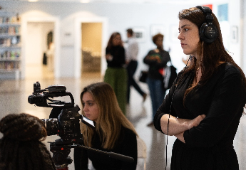 A group of students operating camera equipment to record a video for a project.