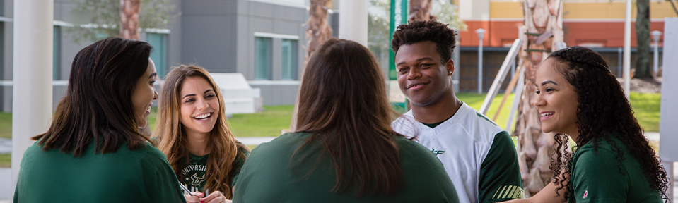 A group of USF international freshmen students chatting on campus.