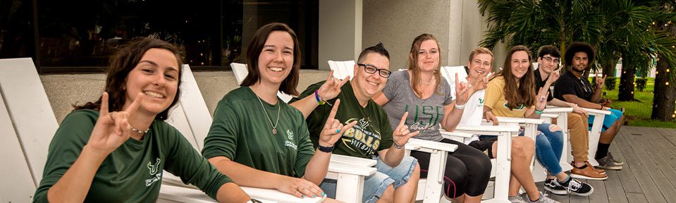 A row of USF international transfer students holding up the bulls sign.