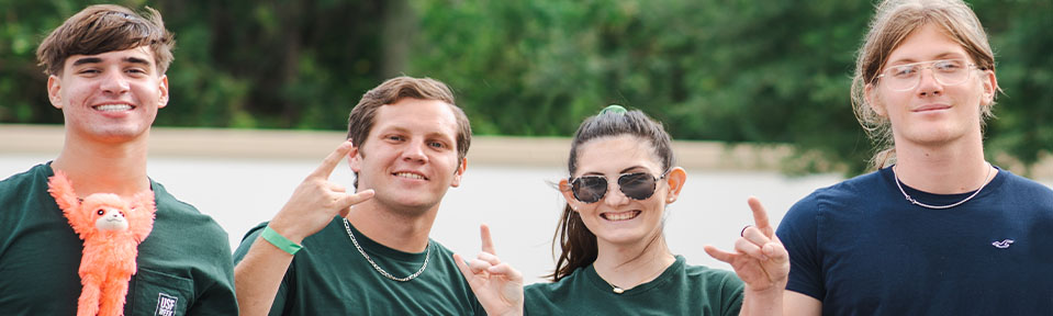 Four USF students holding up the bulls sign.