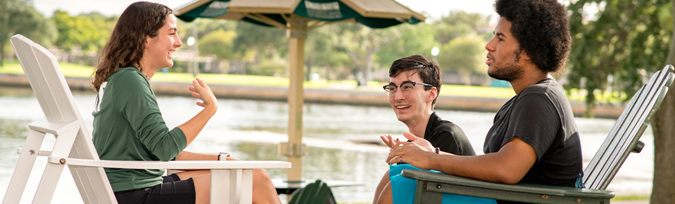 Three USF students hanging out on campus by the water.