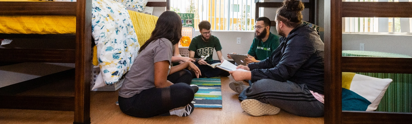 A group of students studying together in a residence hall room.