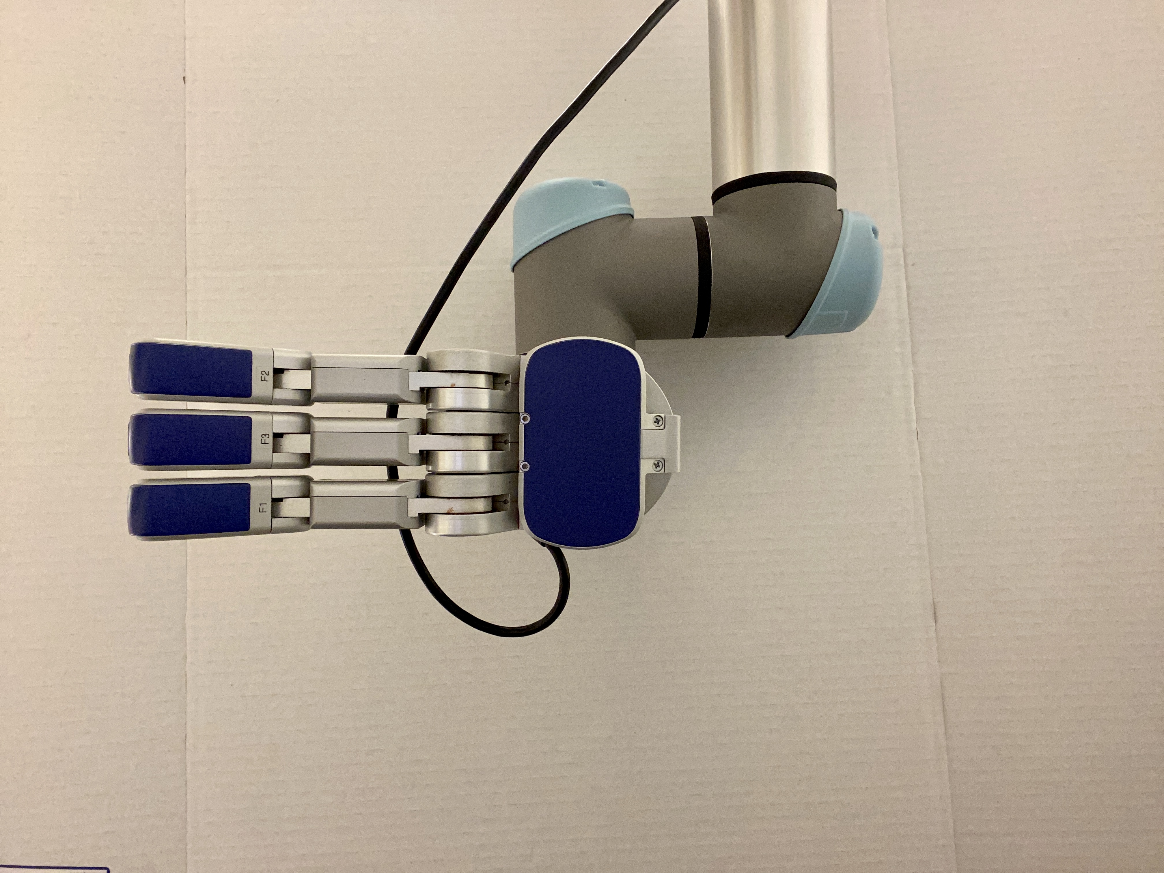 A robotic arm with a blue and silver hand is depicted, featuring articulated fingers labeled F1, F2, and F3, set against a plain white background. The arm's design suggests functionality, highlighting advanced technology in automation.
