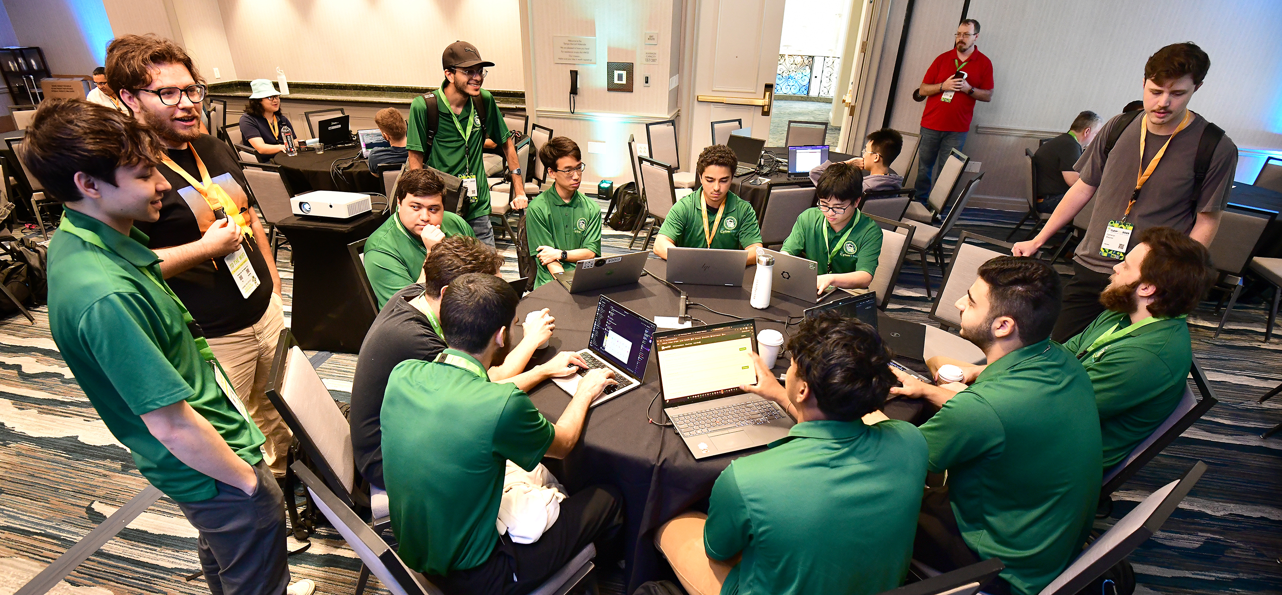 University of South Florida's CyberHerd members gather around a table at the start of a capture the flag competition at CyberBay 2025. Photos by Jeremy Maready, Bellini College of Artificial Intelligence, Cybersecurity and Computing