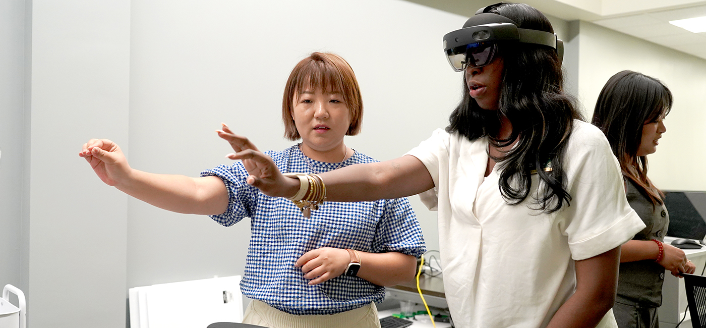 Xiangfei Kong works with another student who is using virtual reality goggles