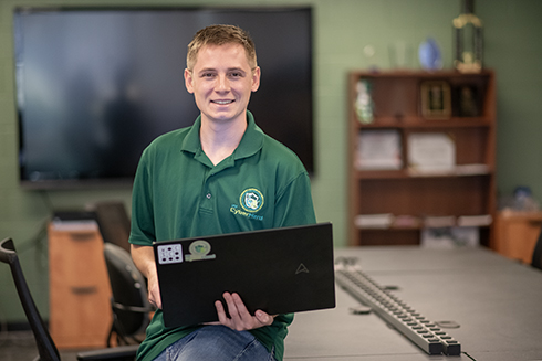 Jackson Liveringhouse sitting on a table inside the cyberherd room.