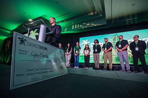 University of South Florida students and the university president accept an oversized check from Peter Bellini of connect secure.