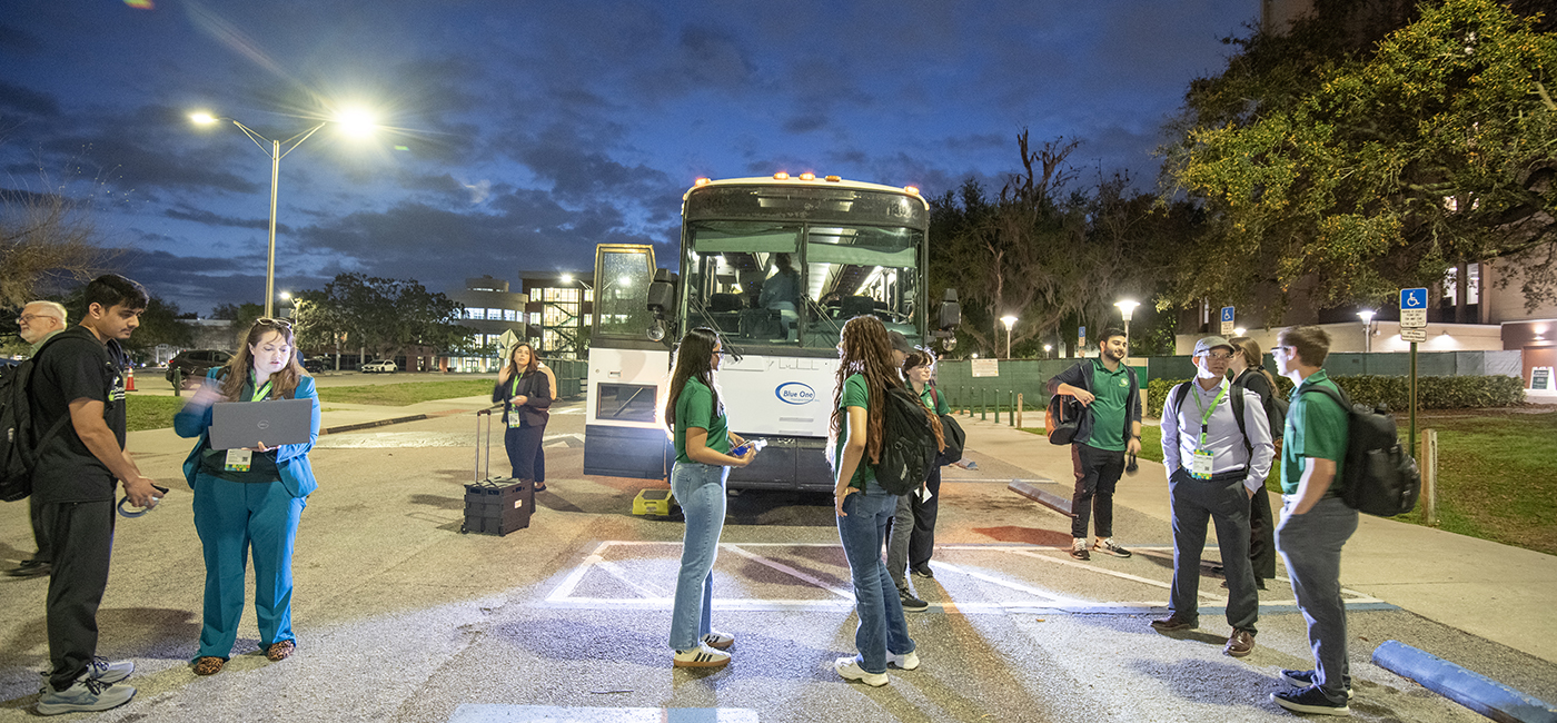 USF students prepare to load a bus before dawn to attend the CyberBay 2026 Summit in downtown Tampa.