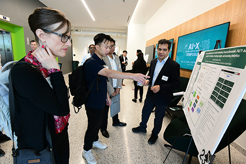 A Bellini faculty member discussing his poster research presentation during the symposium.