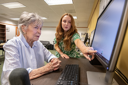 PHD student Marlena Bolton describes how an AI system for seniors works to Jeanie Plyler.