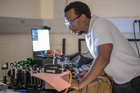 John Murray Bruce works with a laser in his lab.